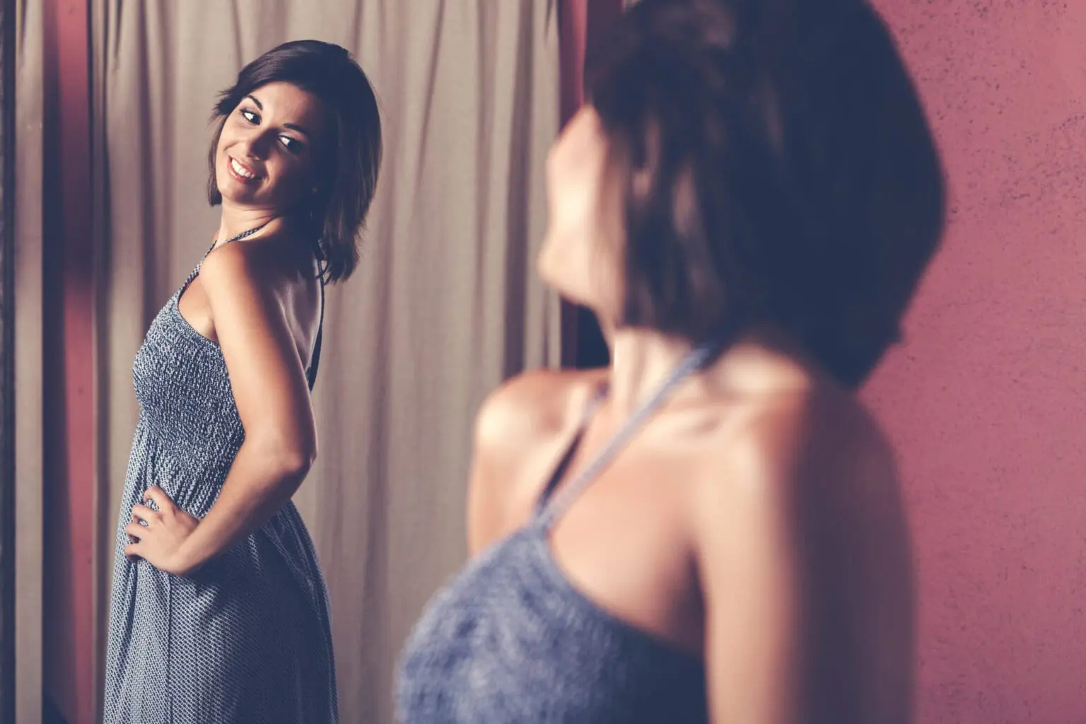 woman looking at reflection in mirror